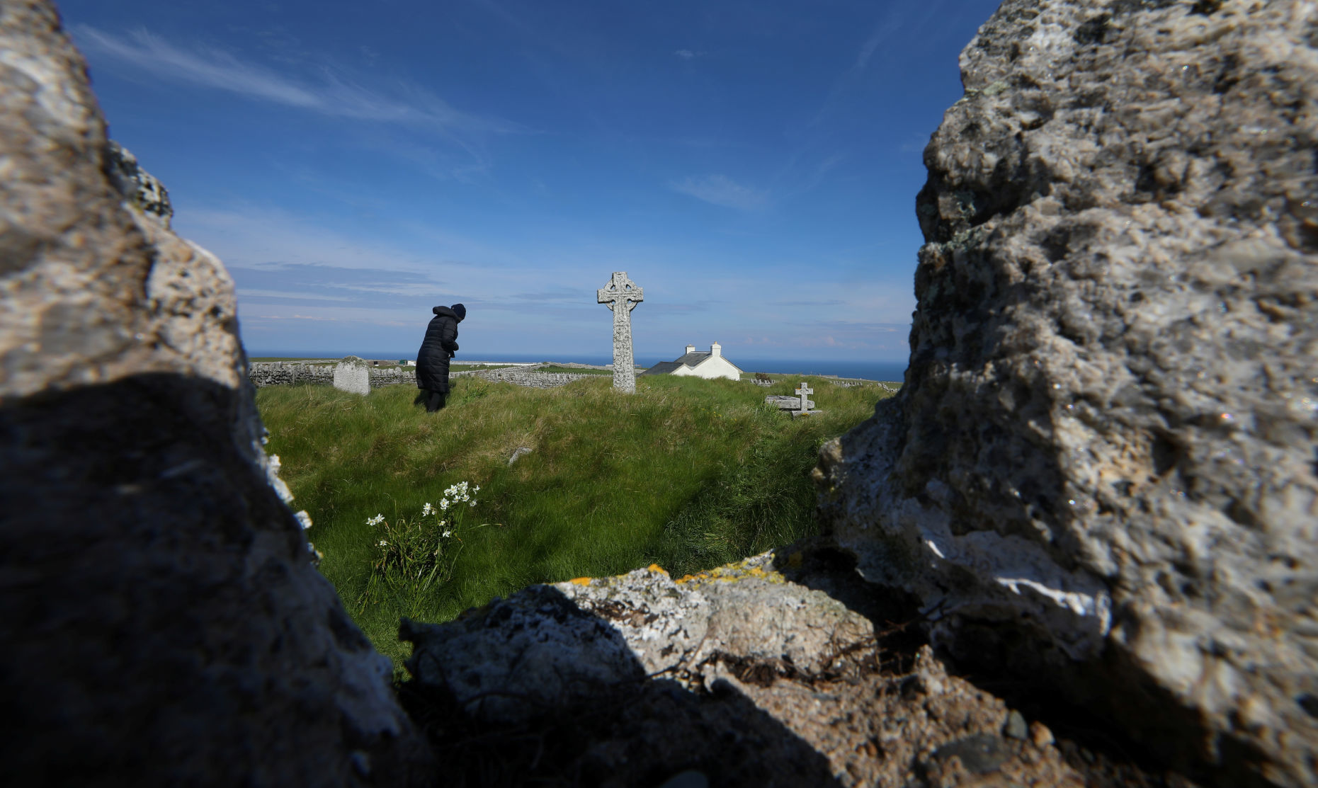 A person walks through the old cemetery on Lundy